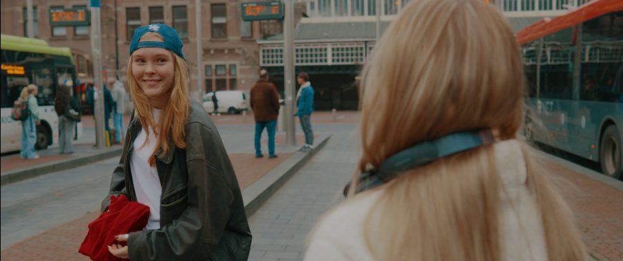 Hazel: a smiling woman in a blue cap and leather jacket on an Amsterdam street