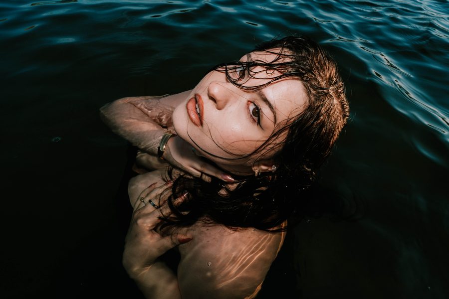 Lake Myra: a woman with wet hair floating in dark lake water
