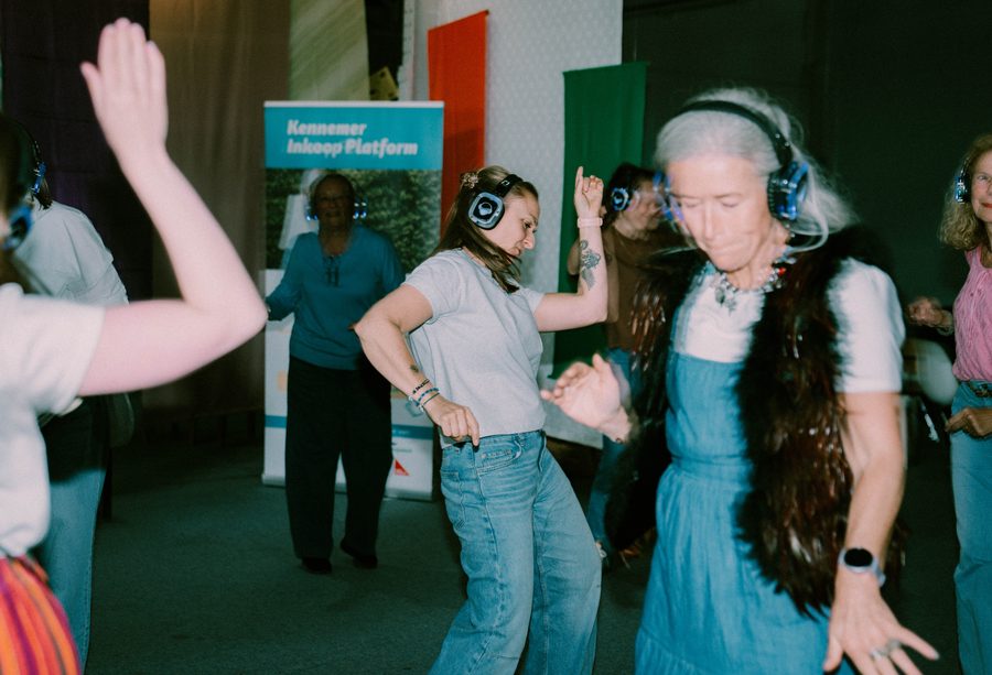 Ratata: silent-disco dancers in headphones, one with grey hair in motion blur
